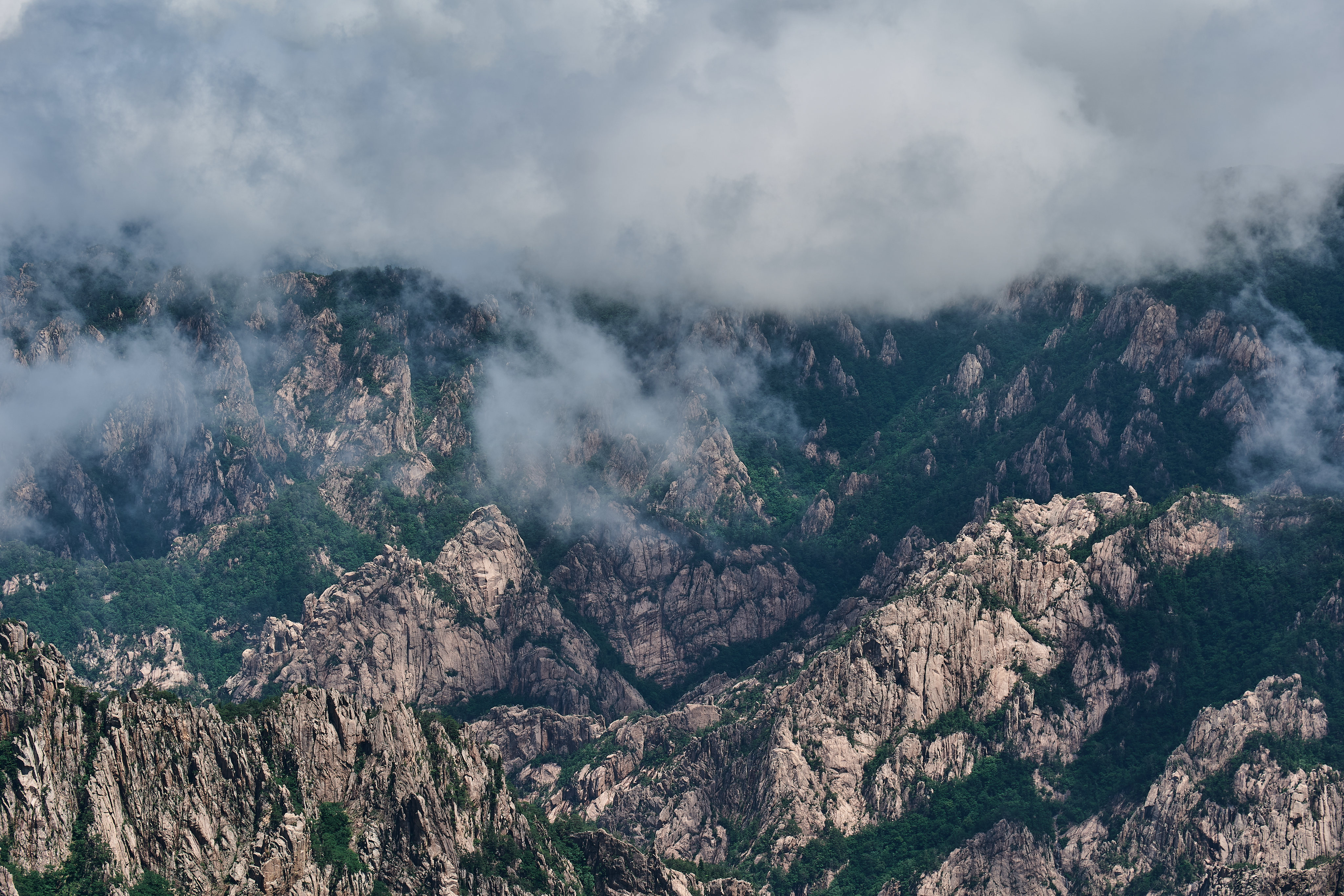 Clouds drifting across a landscape of rugged mountain peaks